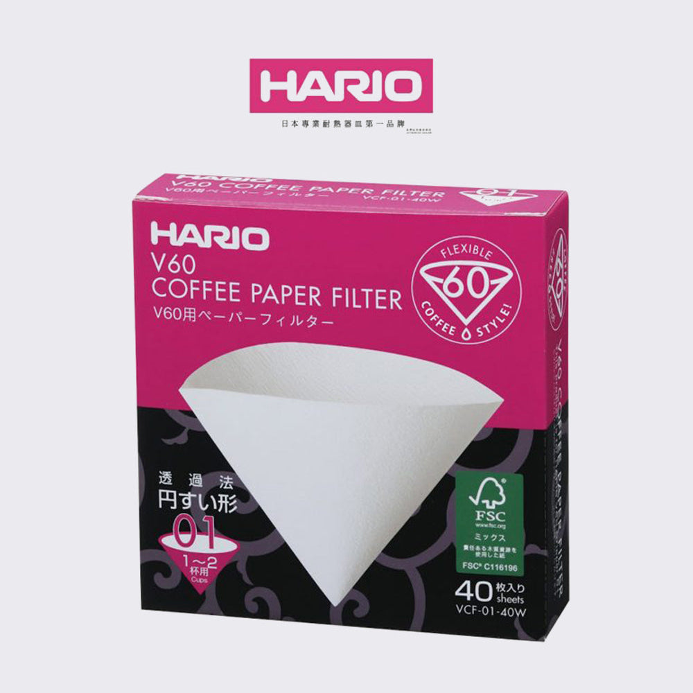 A pack of Hario V60 coffee paper filters in a pink and black box, with a white filter visible on the front.